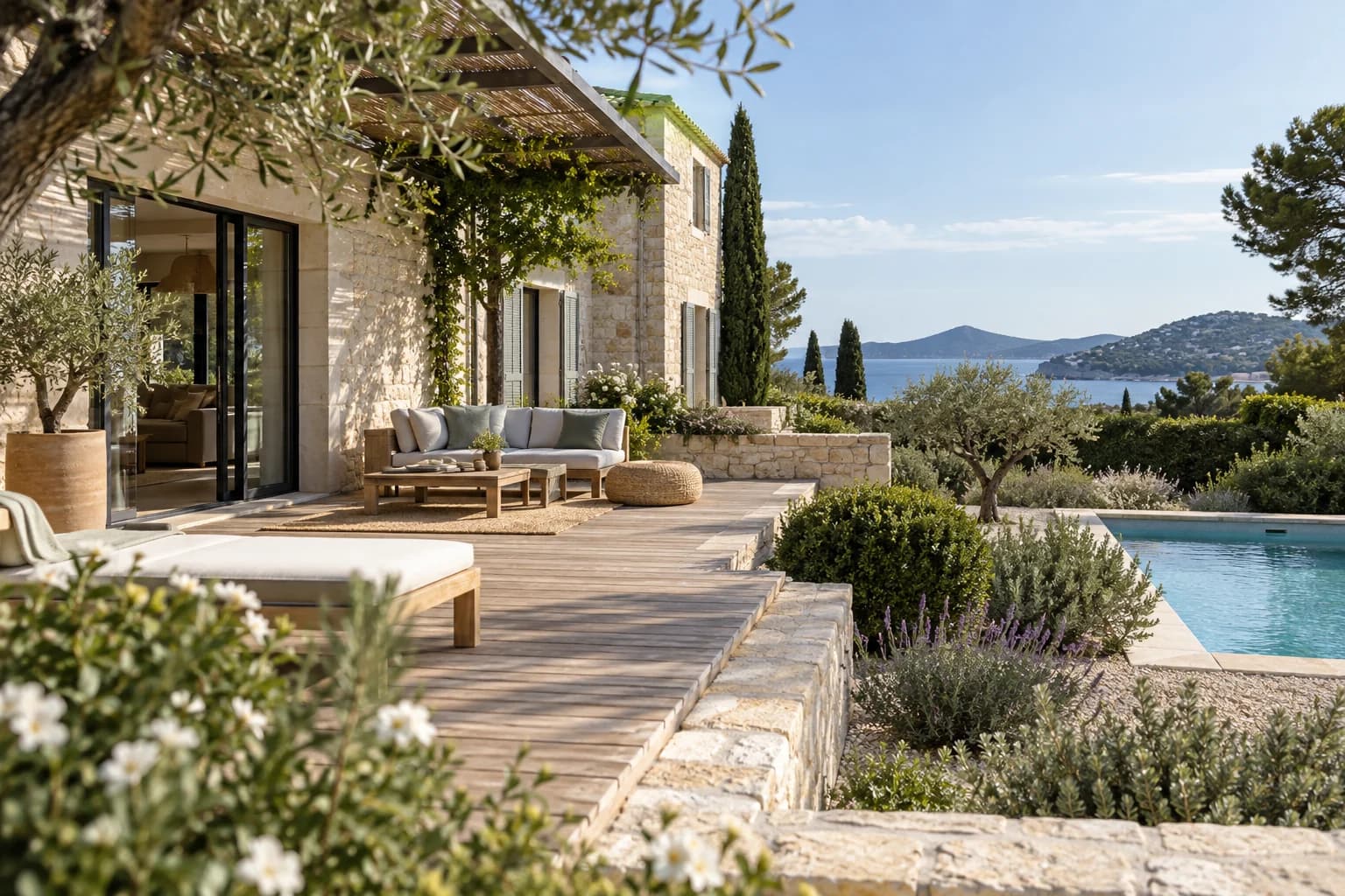 Terrasse paysagée en pierre et bois avec piscine.