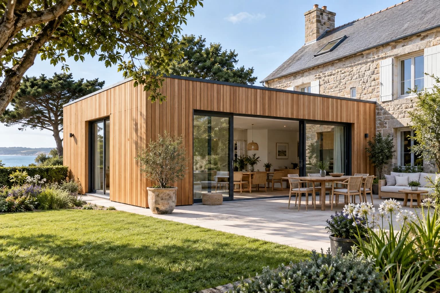 Extension contemporaine en bois d’une maison en pierre.